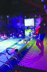 The lifeguard watched the people floaing in the swimming pool.