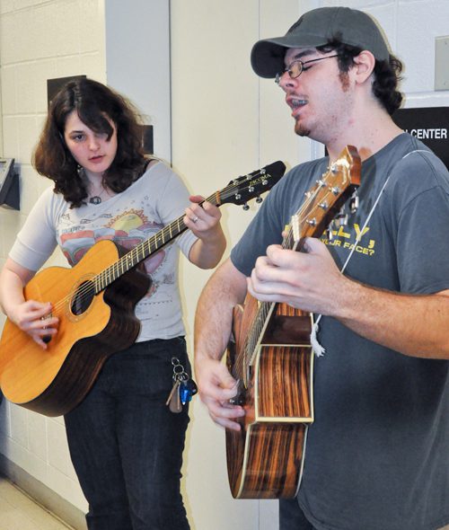 Musicians practicing with acoustic guitars together.