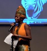 Speaker presenting on stage with microphone