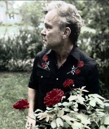 Man holding roses in a garden