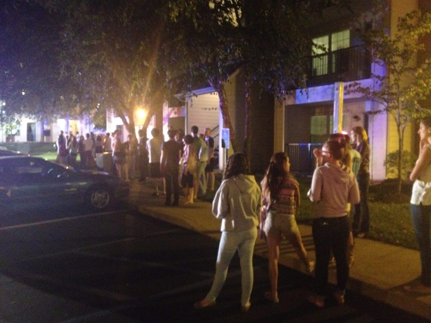 Residents standing outside illuminated building