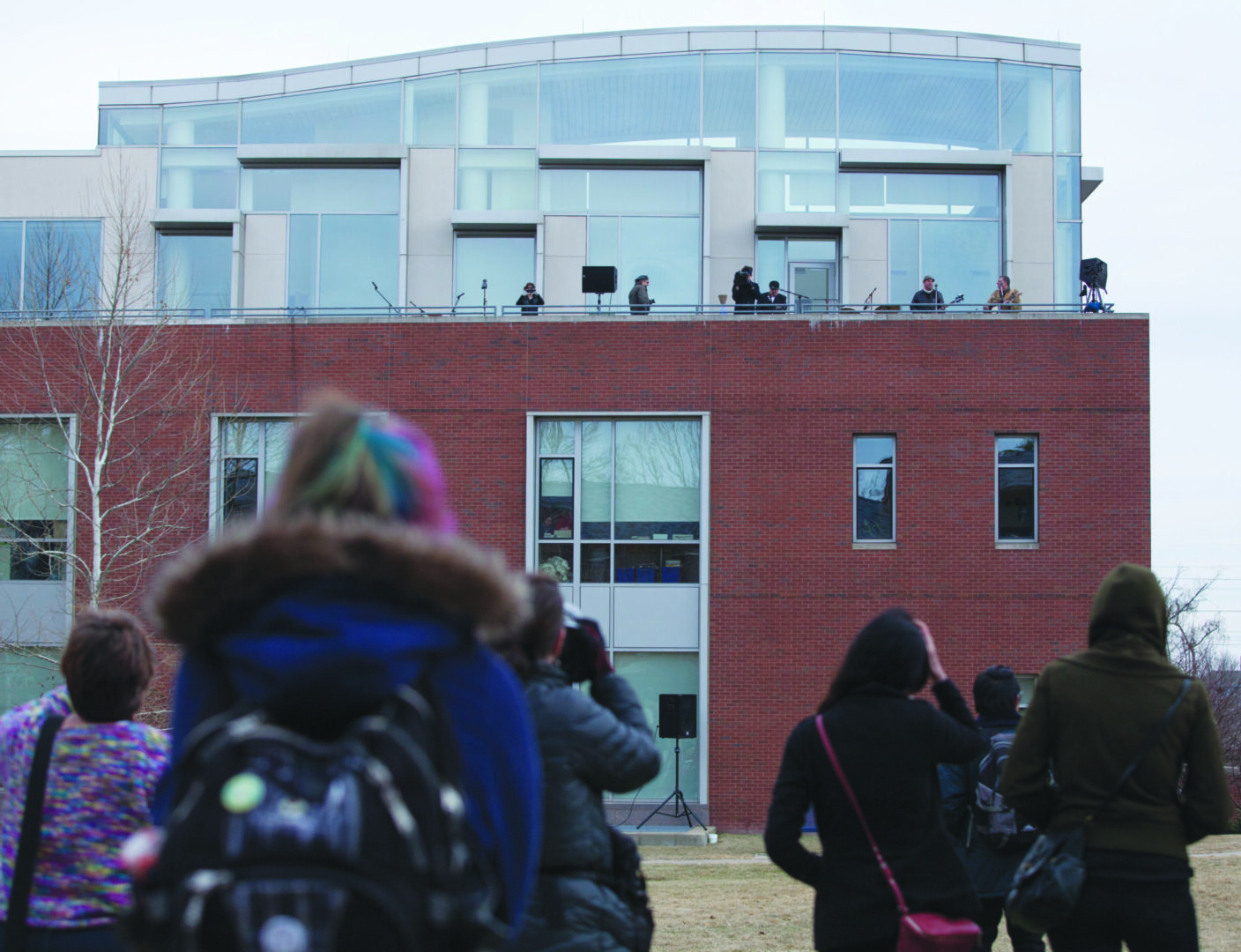 People watching performance on building rooftop