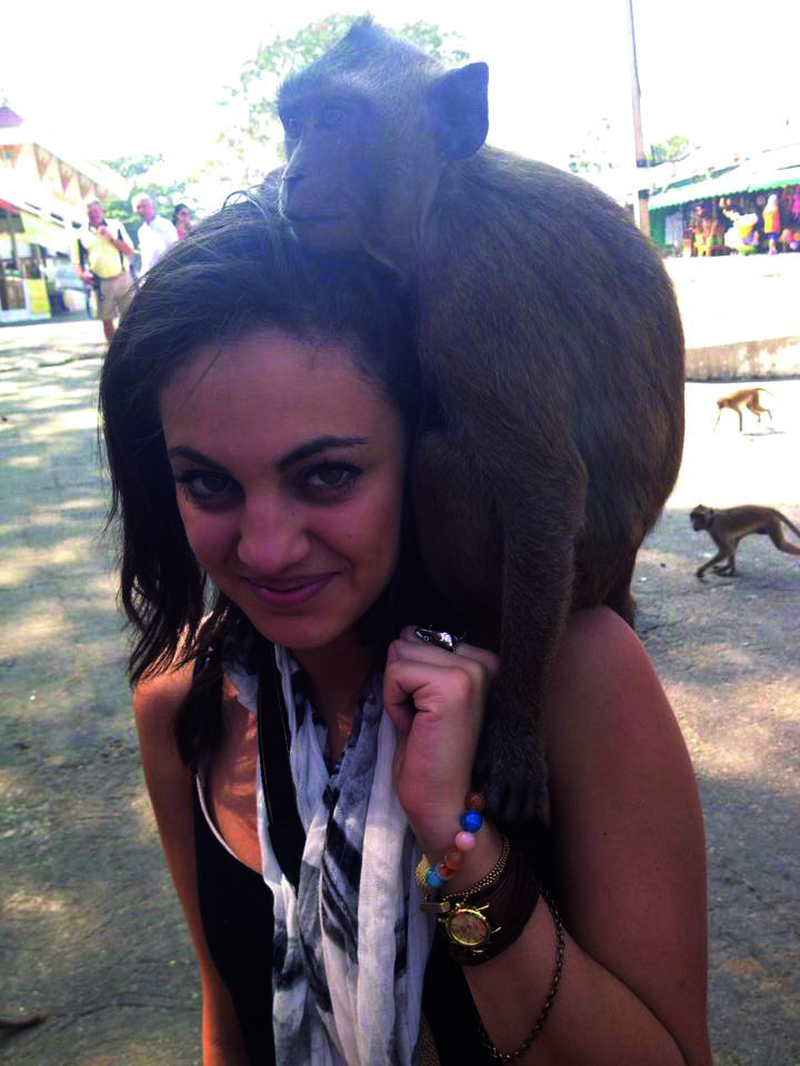 Smiling woman and monkey posing together