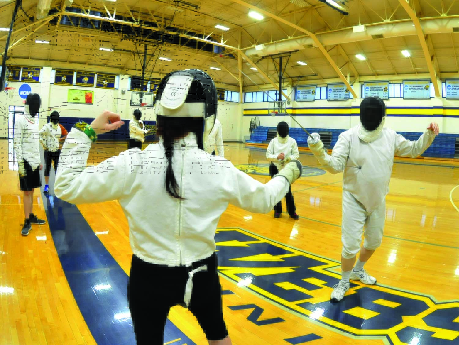 Fencing practice in gymnasium