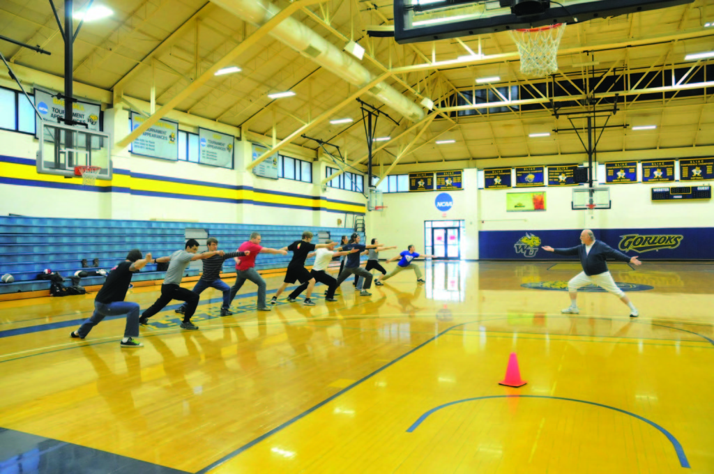 PHOTO BY MEGAN WASHAUSEN / The Journal Adjunct professor Michael Long leads lunge exercises in his Fencing II class to teach his students proper form and technique. The class meets on Tuesdays and Thursdays in Grant Gymnasium from 11:30 a.m. to 12:50 p.m.