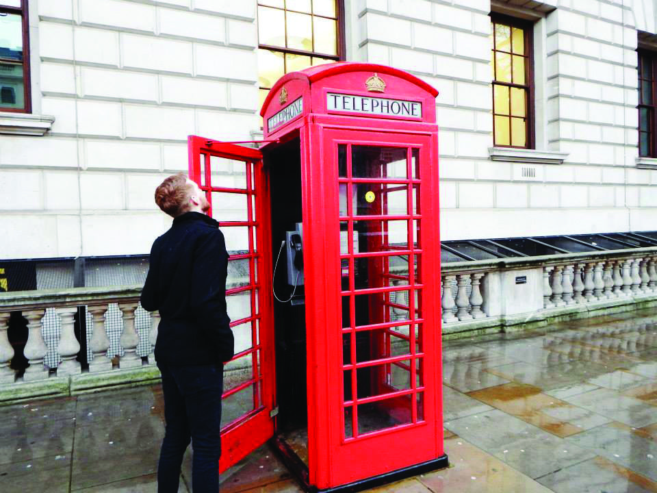 Person standing by red phone booth