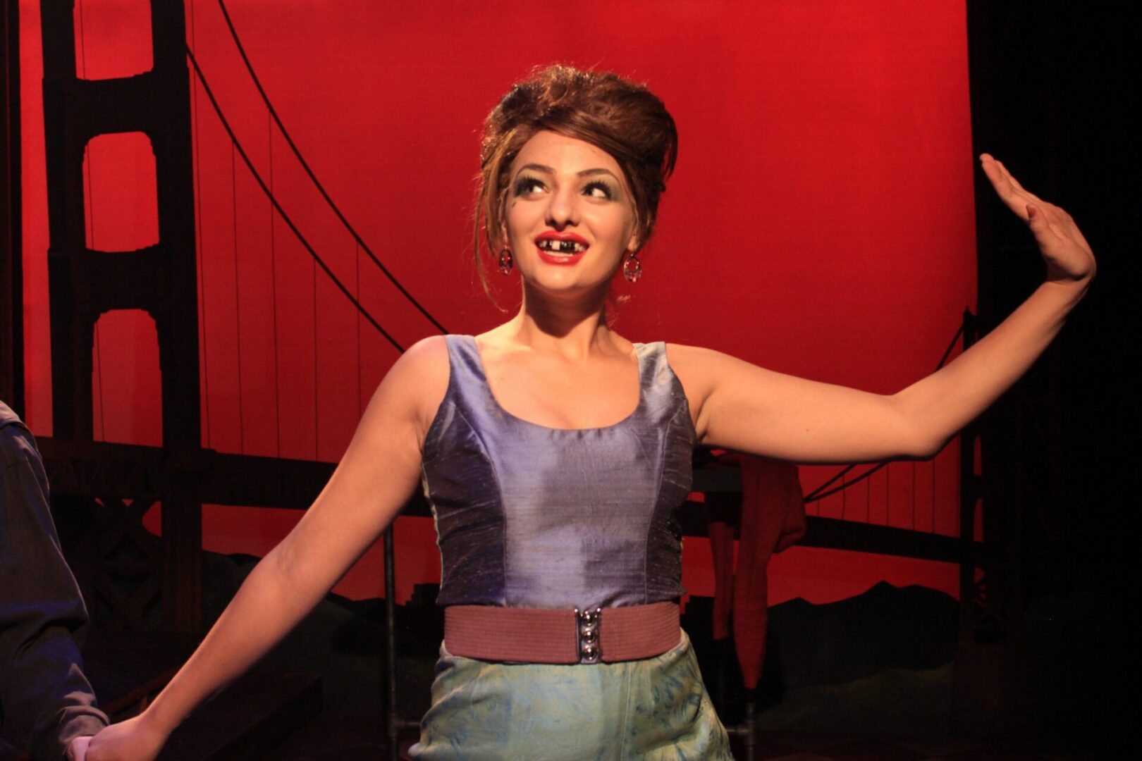 Performer on stage with red backdrop