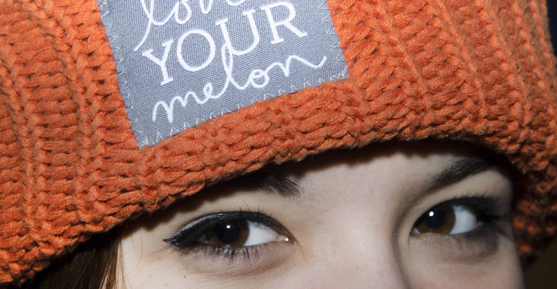 Orange knit hat with embroidered patch