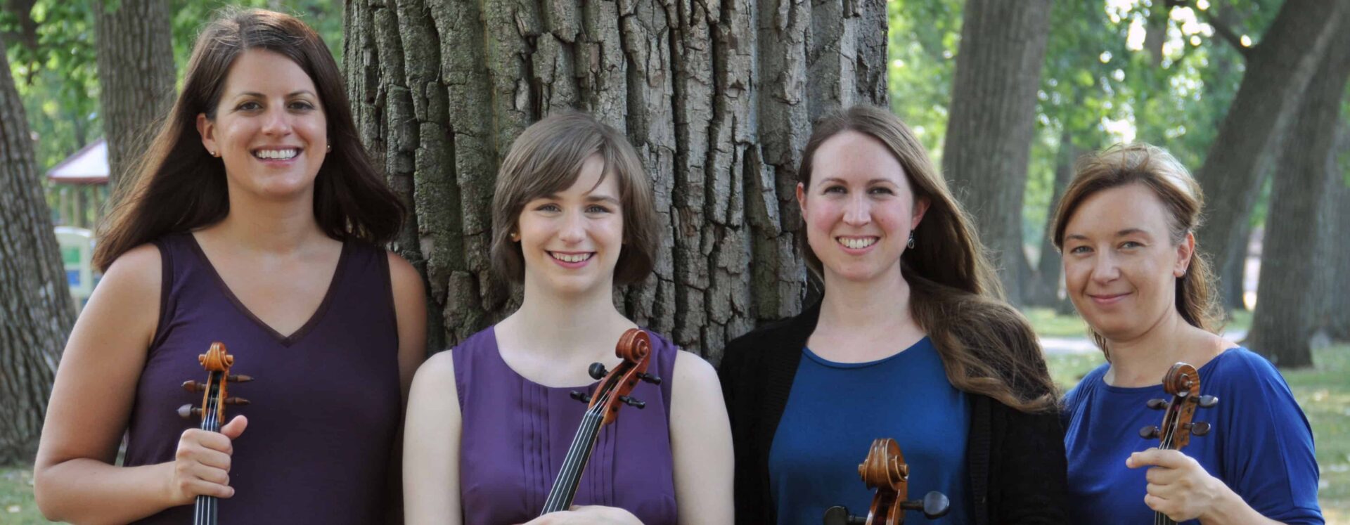 String quartet posing under a tree