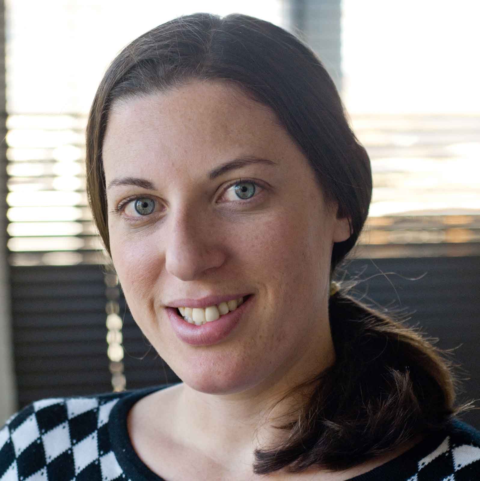 Woman with dark hair smiling at camera