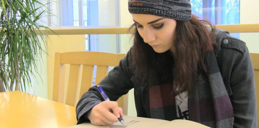 Individual taking notes indoors