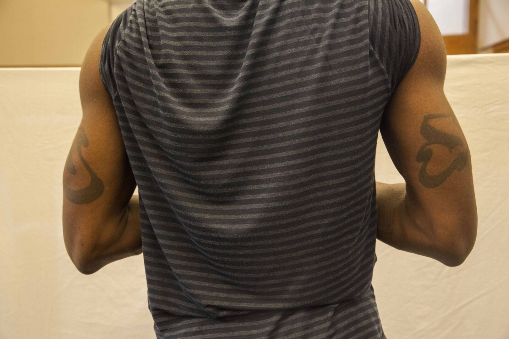 Man with tattoos wearing striped shirt