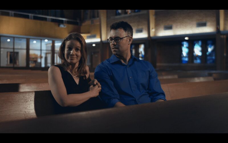 Pair sitting together in dimly lit church