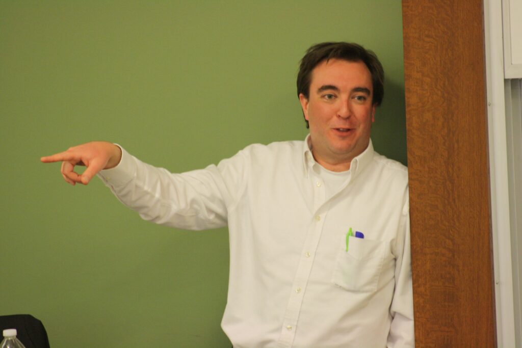 Individual in white shirt pointing left