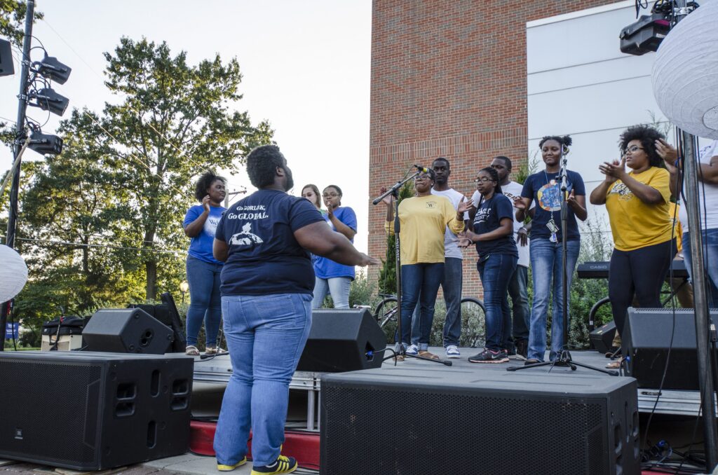 Group singing on stage outdoors