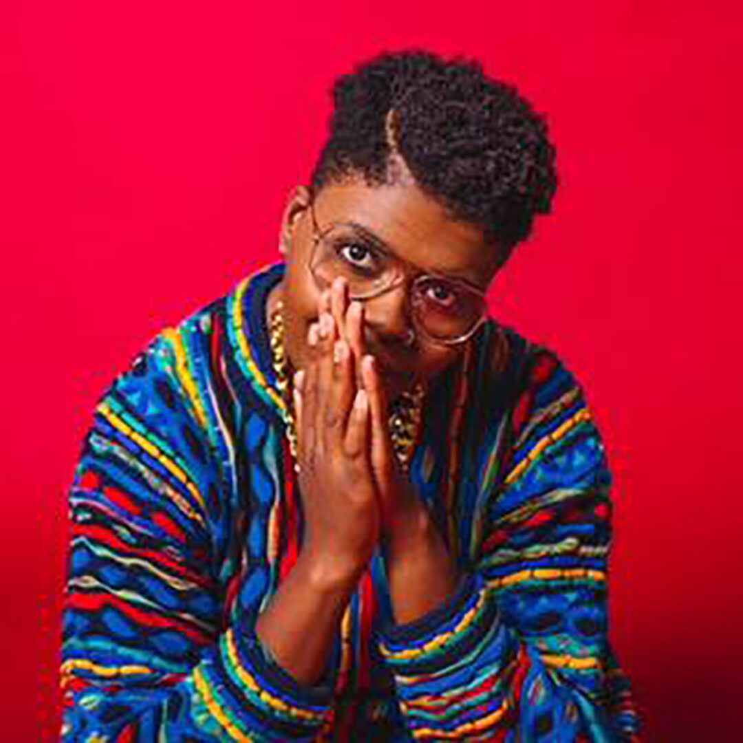 Person in colorful jacket, hands together