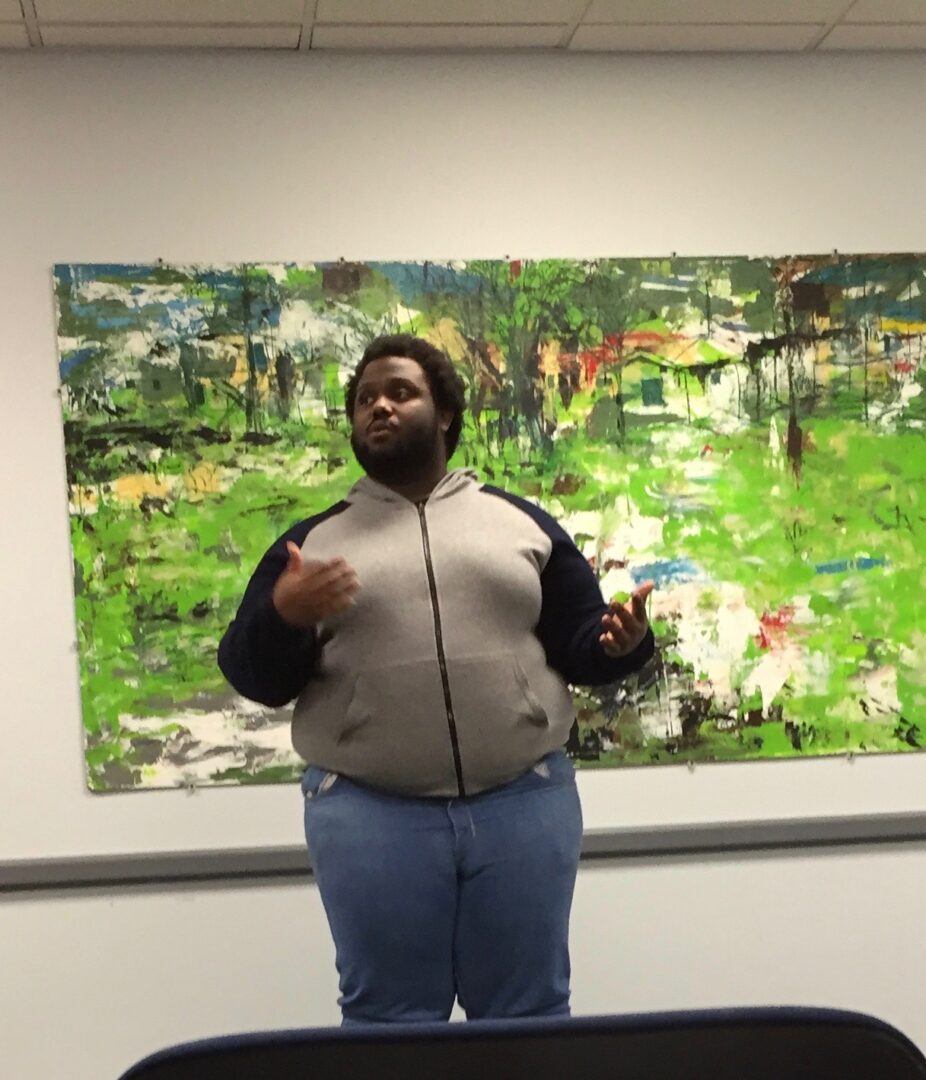 Speaker gestures near colorful artwork