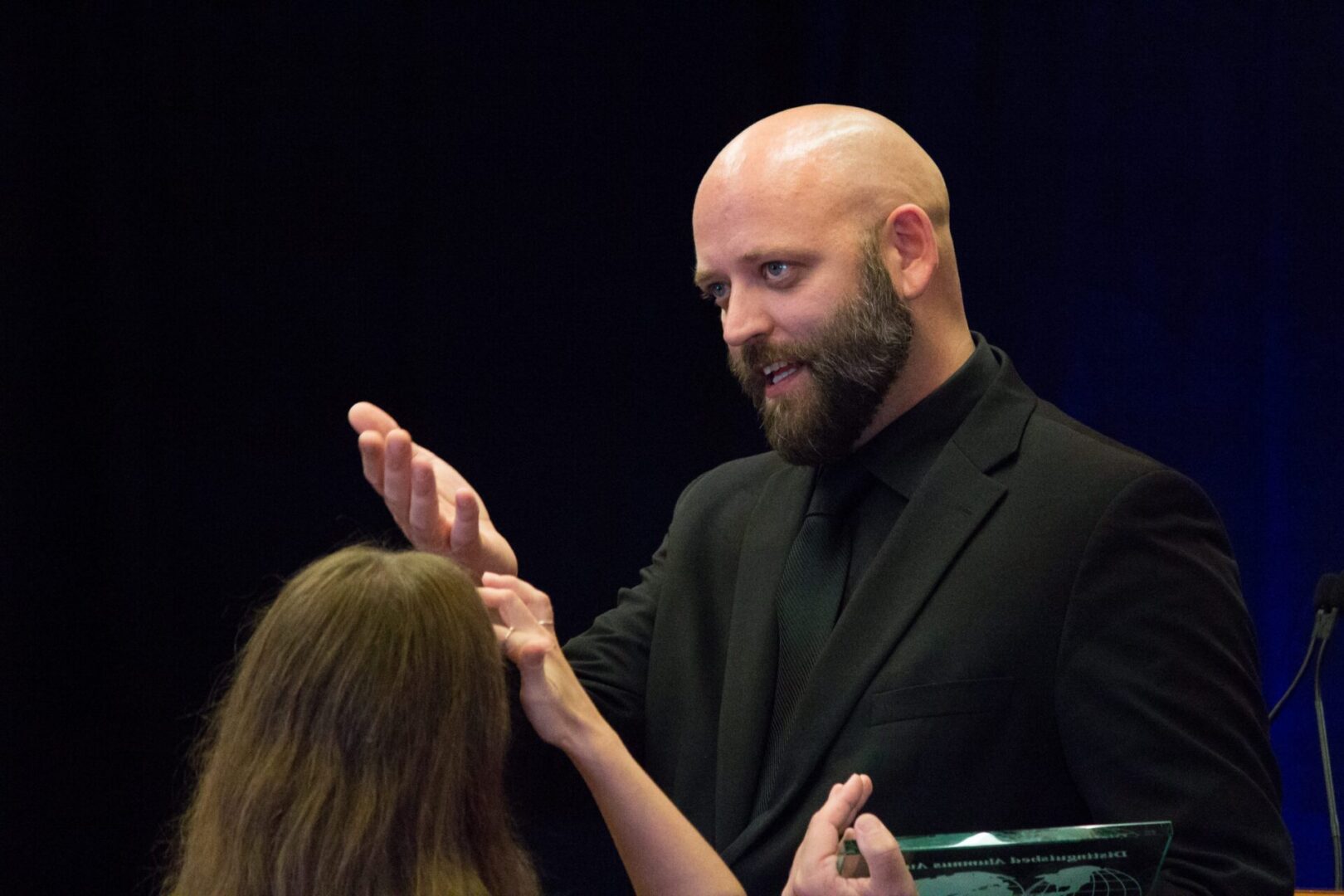 Bald man engaged in conversation