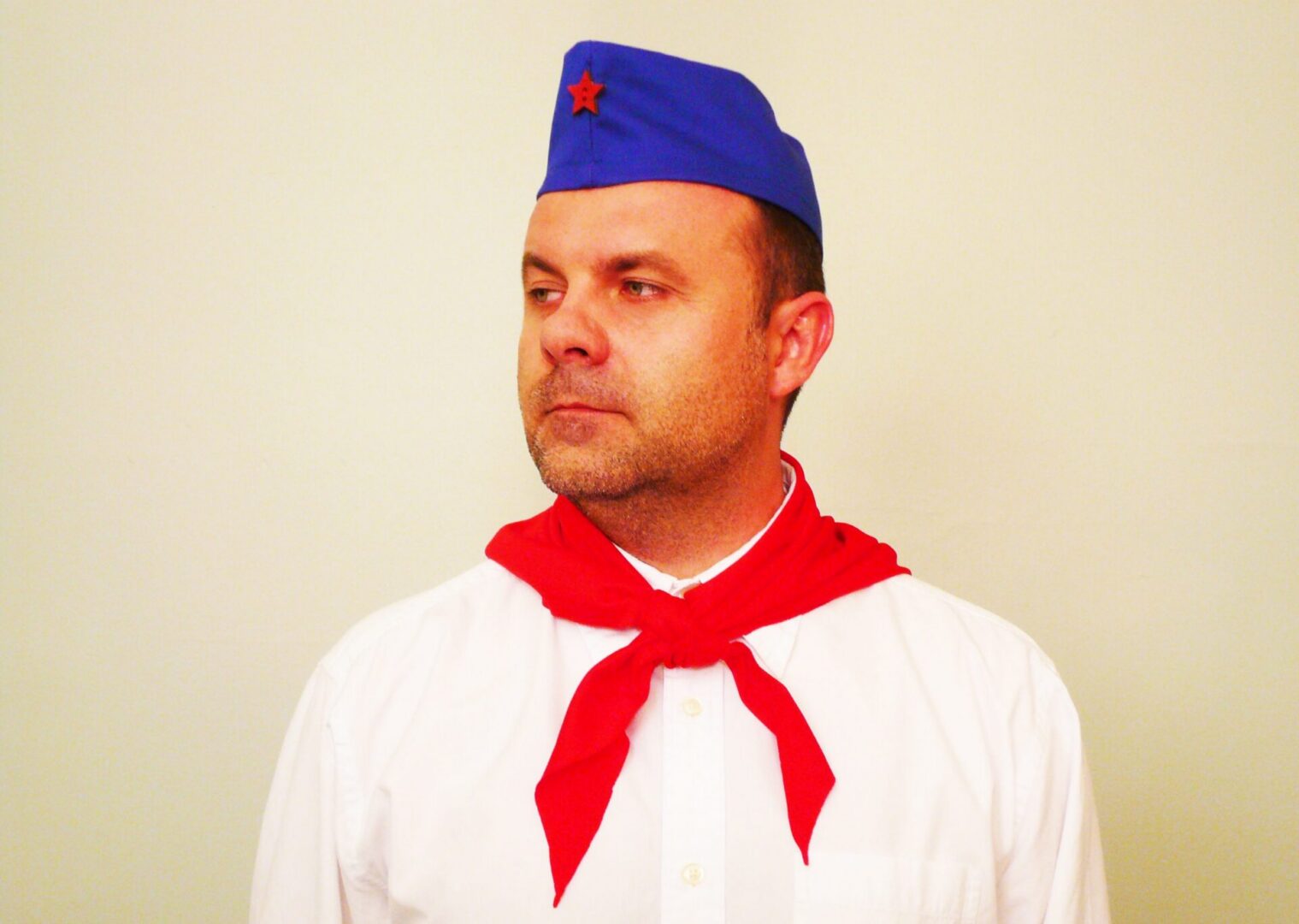 Person wearing a blue cap and red neckerchief