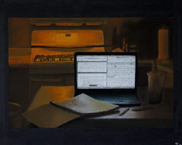 Dimly lit kitchen workspace with laptop