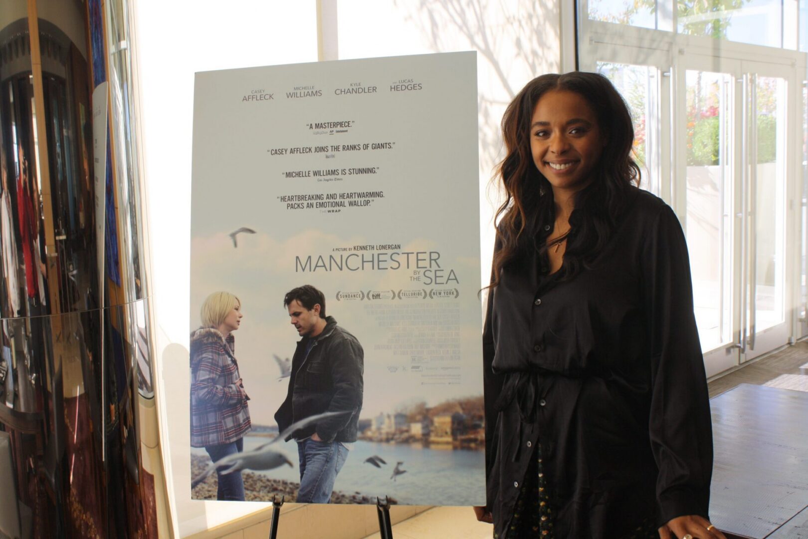 Woman standing beside movie poster