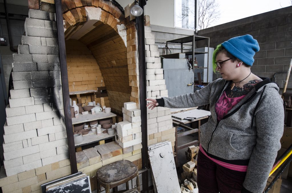 Webster University senior studio arts major Carrie Juenger observes the kiln, which is the oven used to burn or dry pottery and other materials. JORDAN PALMER / The Journal