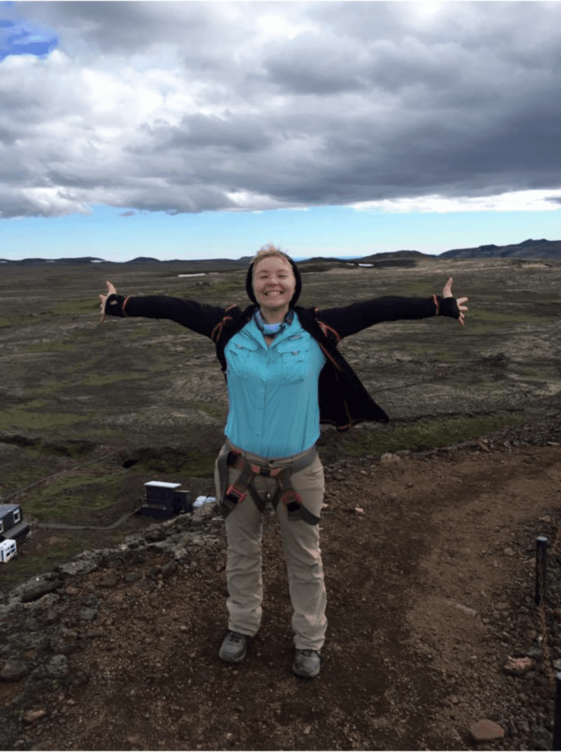 Person standing with open arms outdoors