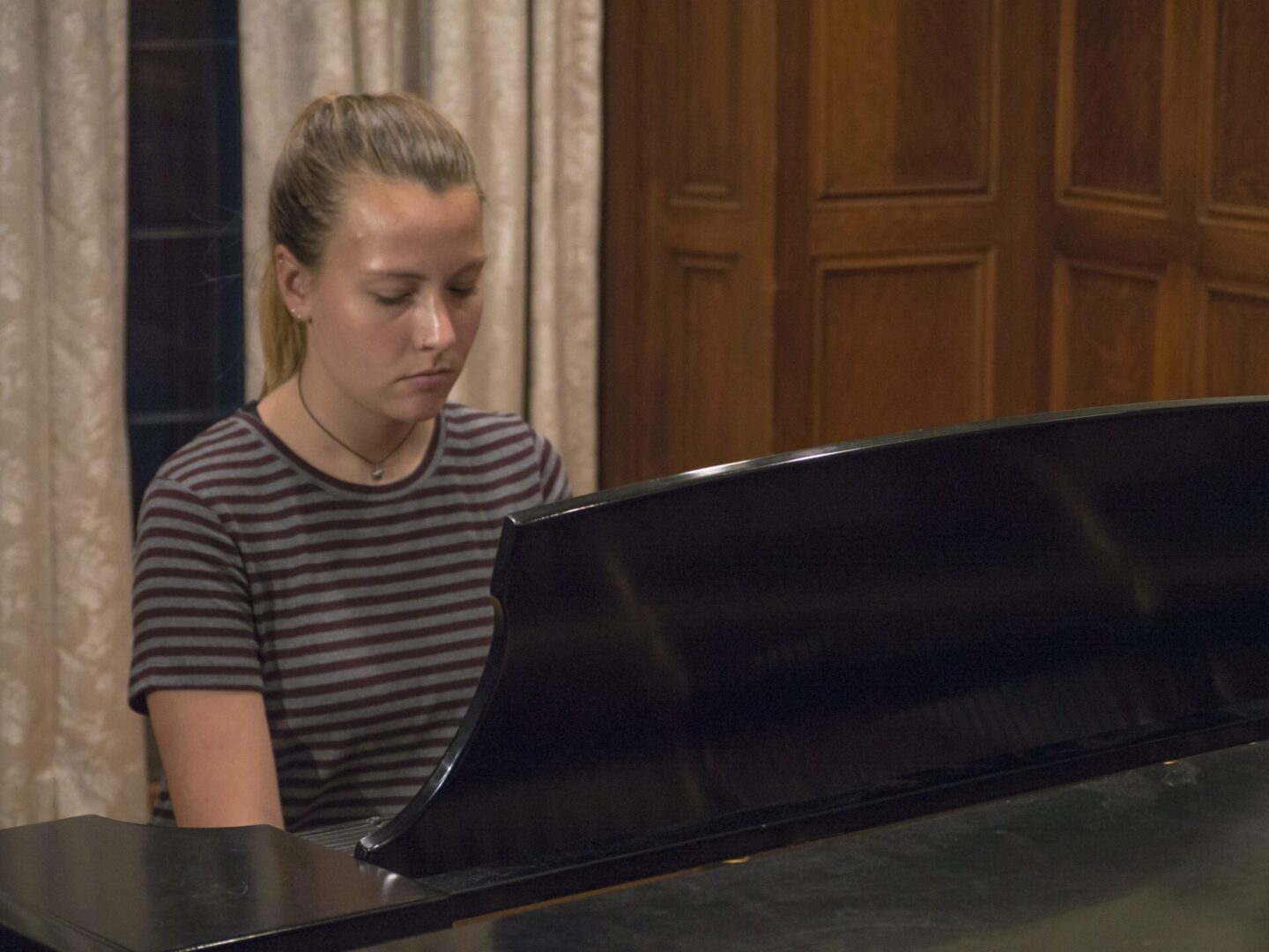 Young pianist in striped shirt playing