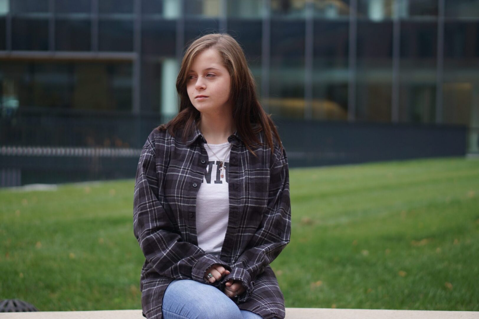 Woman in plaid shirt on campus.
