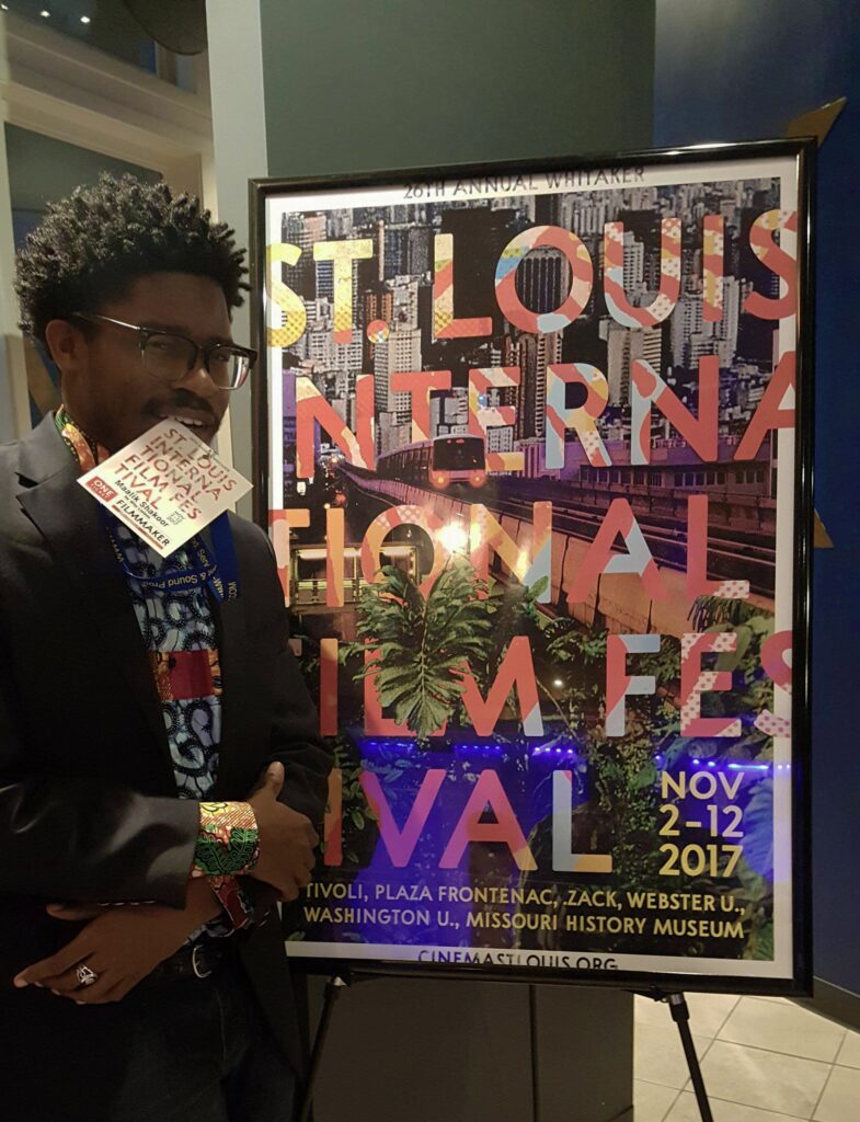 Man standing beside film festival poster