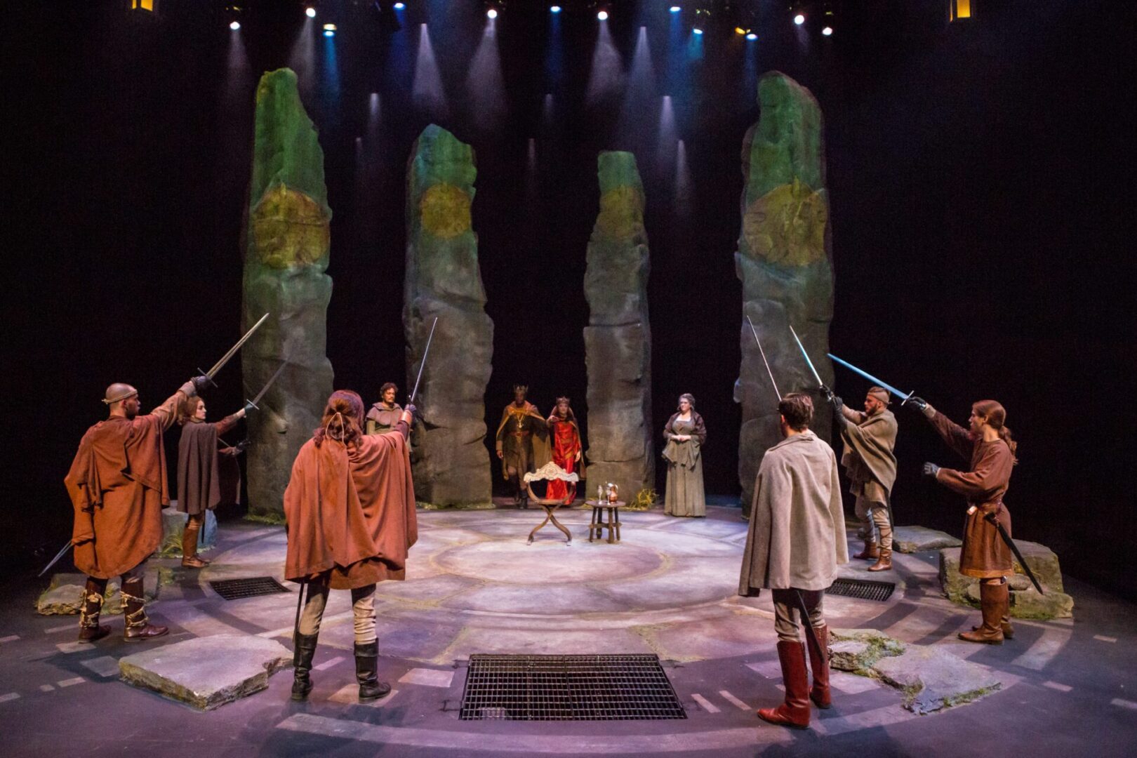 Stage scene with actors and stone pillars