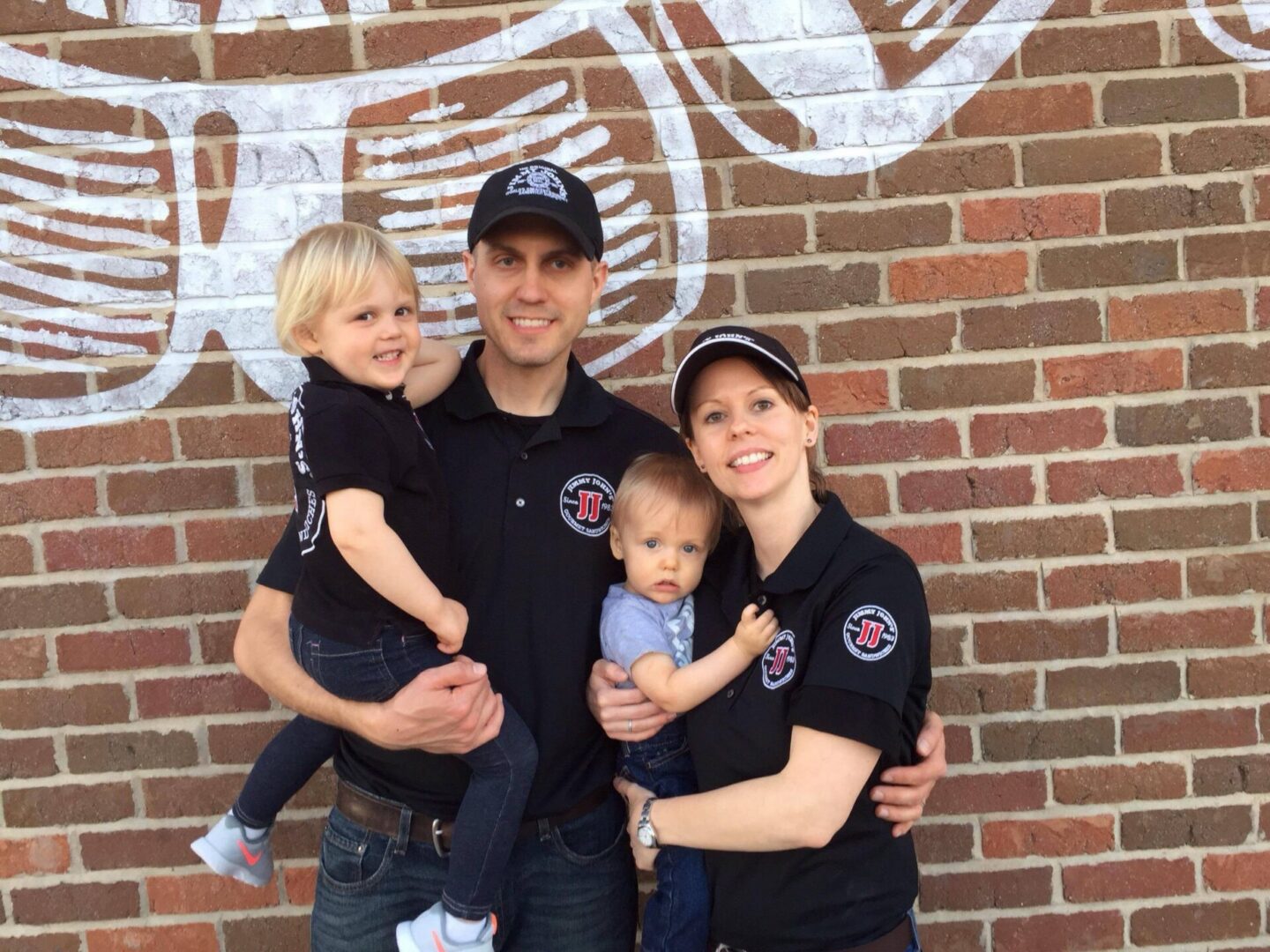 Family in matching outfits against brick wall