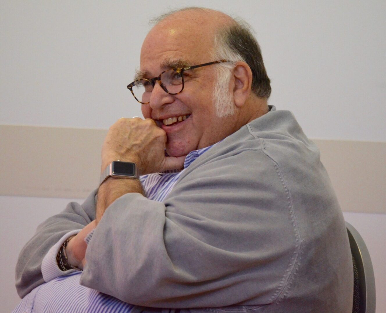Elderly man laughing in a chair