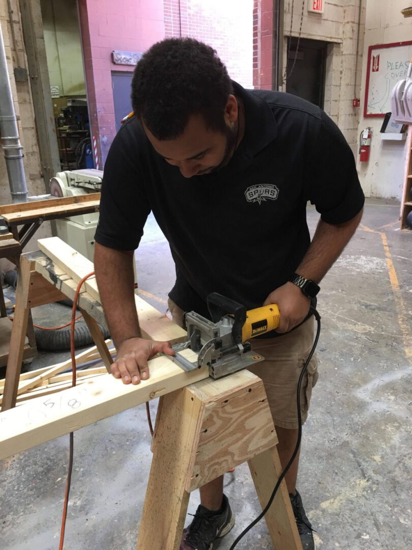 Carpenter cutting wood with electric saw