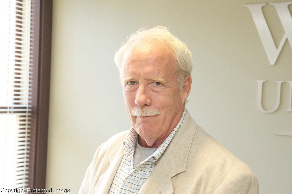 Elderly man in beige suit smiling