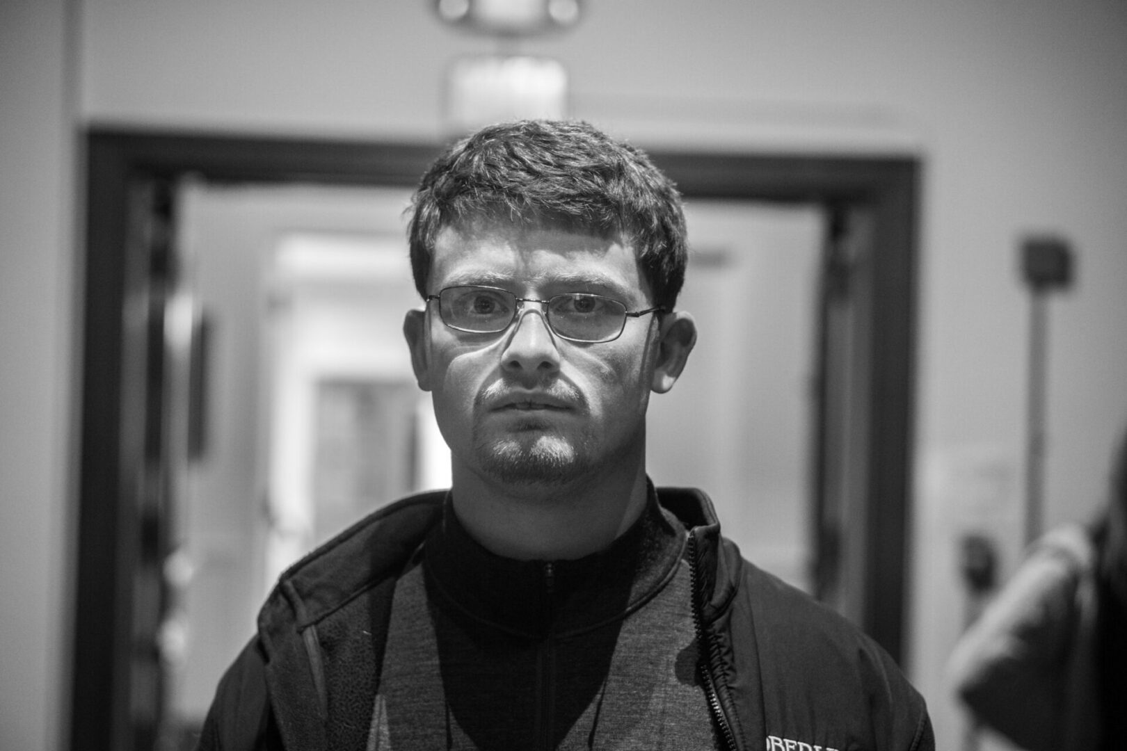 Man with glasses in a hallway