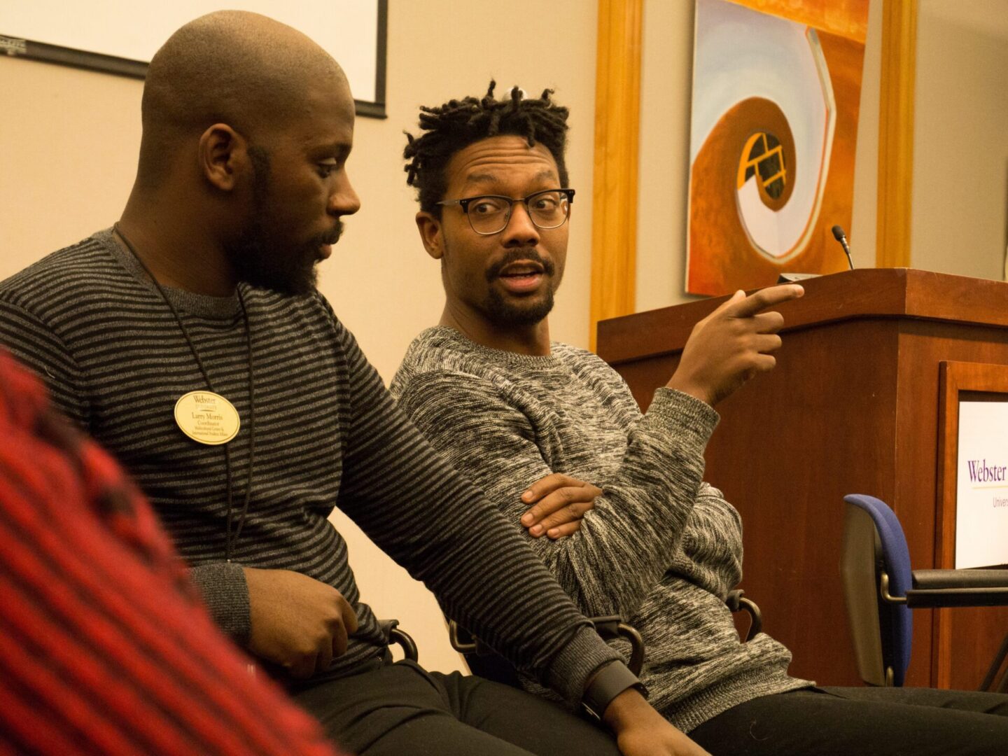 Engaged conversation between two seated men.