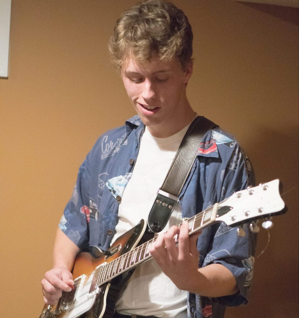 Person playing electric guitar indoors