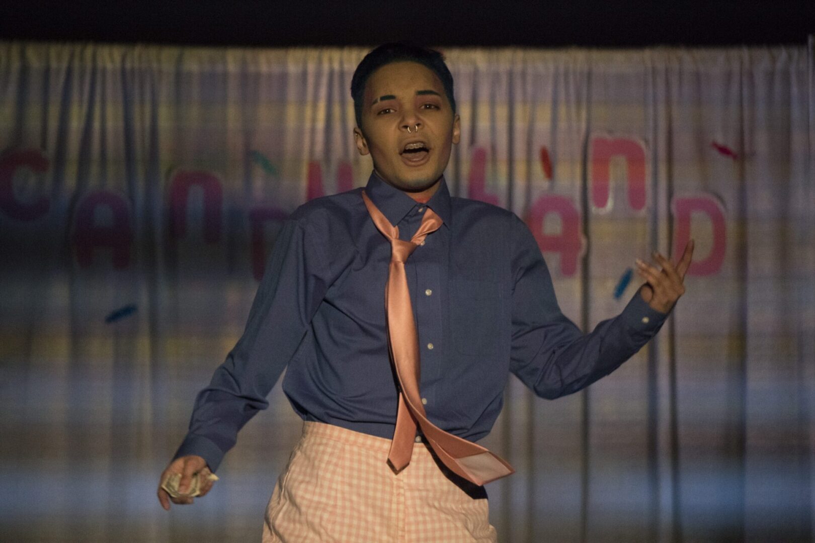 Person singing in blue shirt and tie