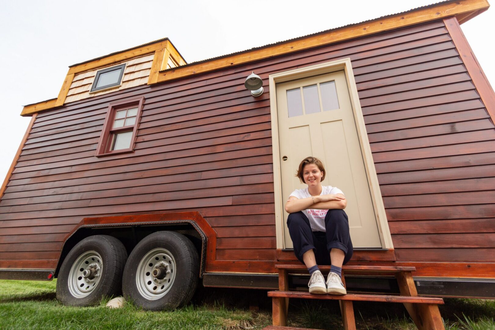 Wooden tiny home exterior with person seated