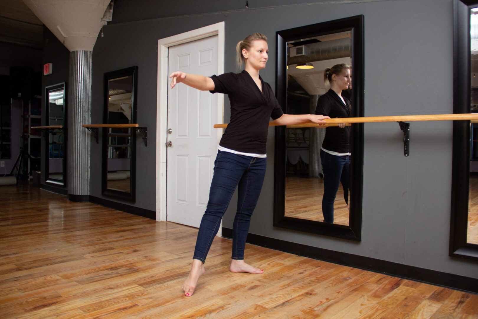 Dancer balancing at barre in dance studio