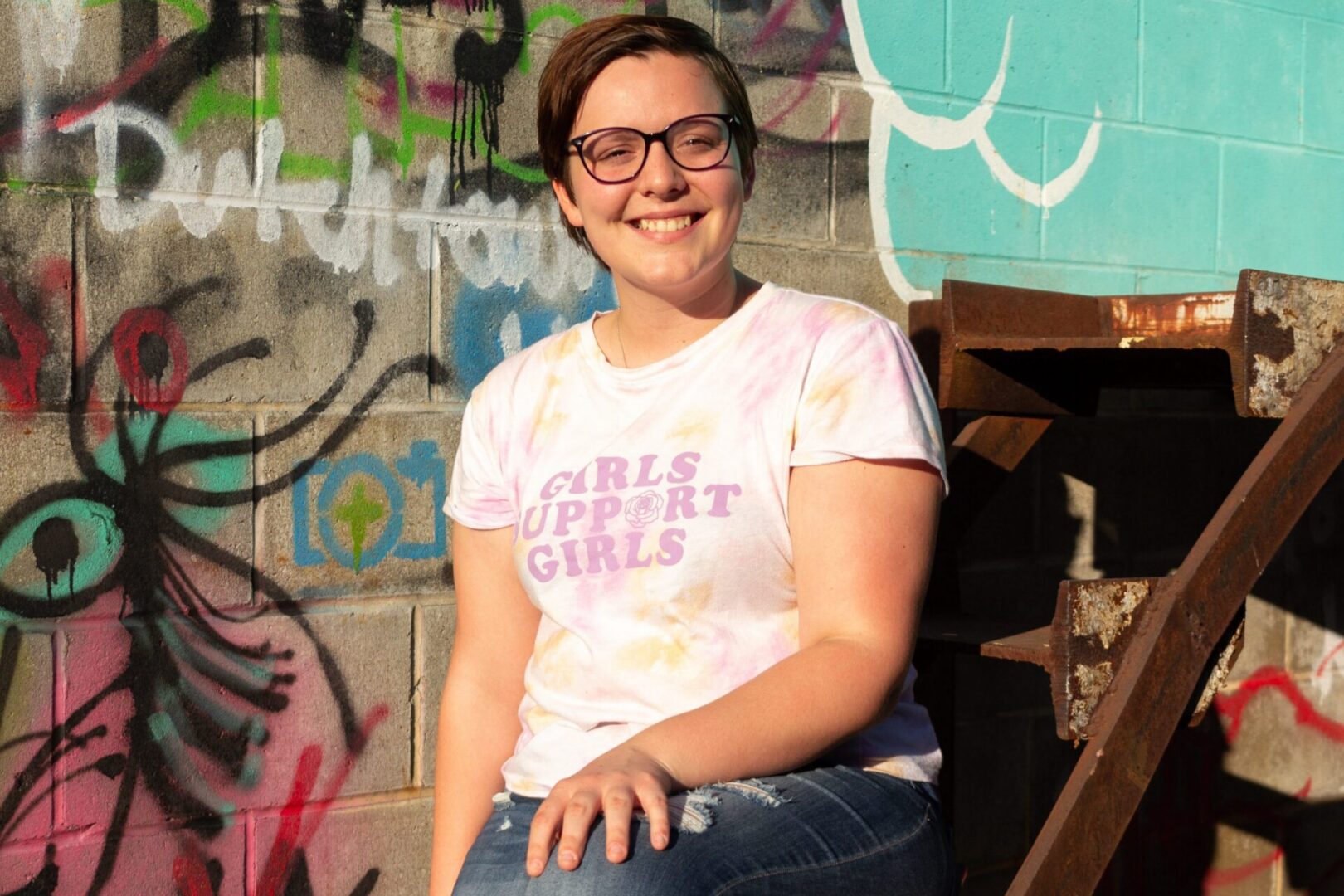 Person sitting on outdoor stairs, happy