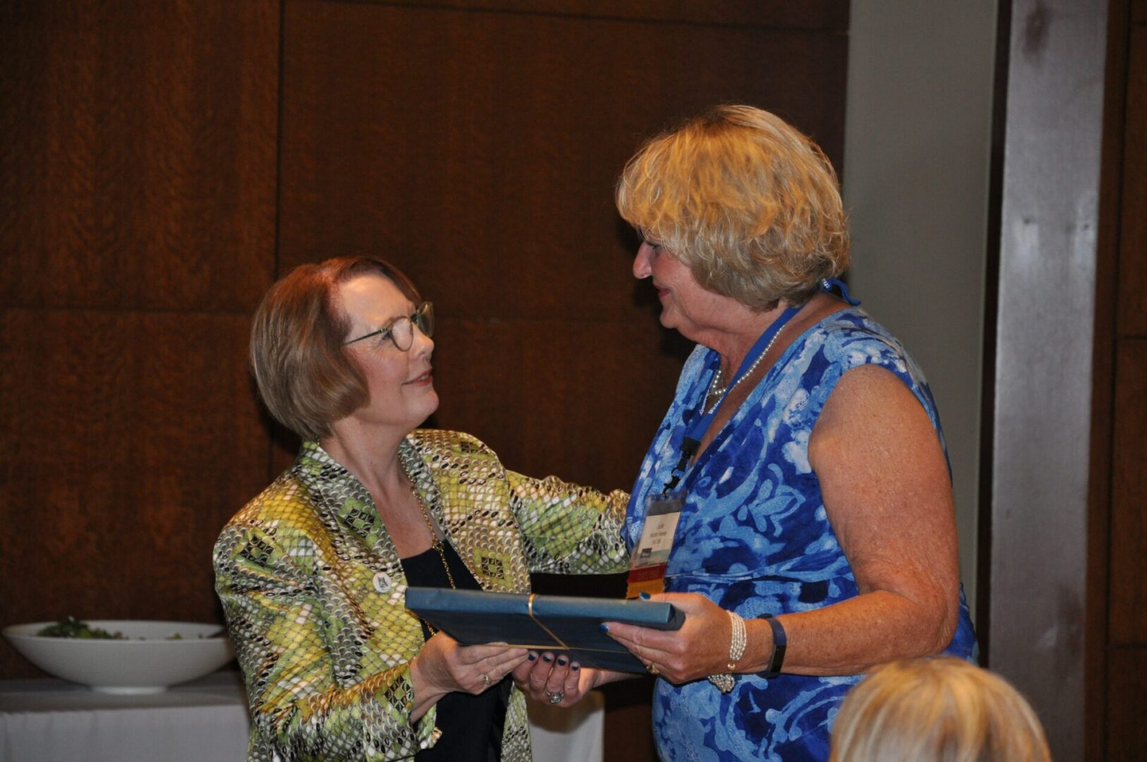 Two women exchanging an award