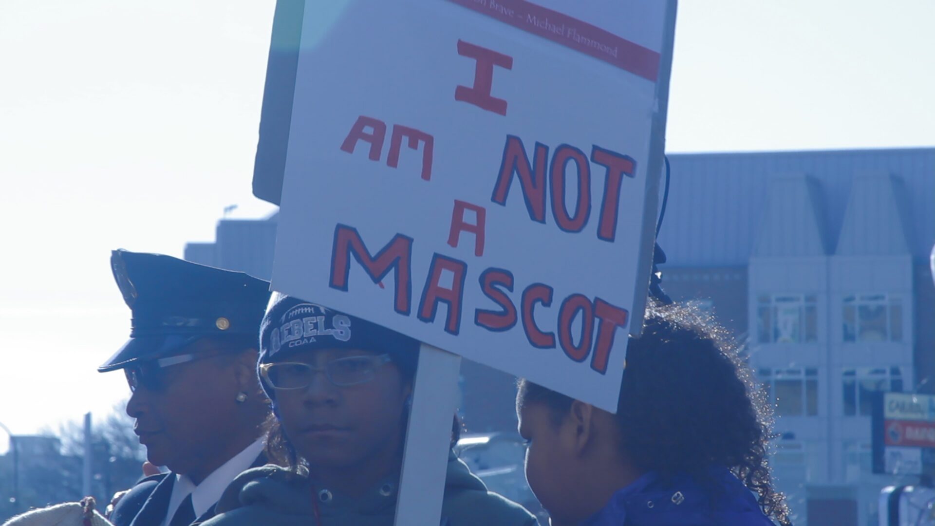 Person with protest sign in crowd.