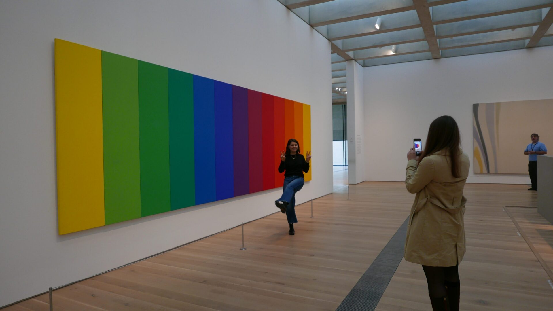 Visitor photographing rainbow-striped artwork