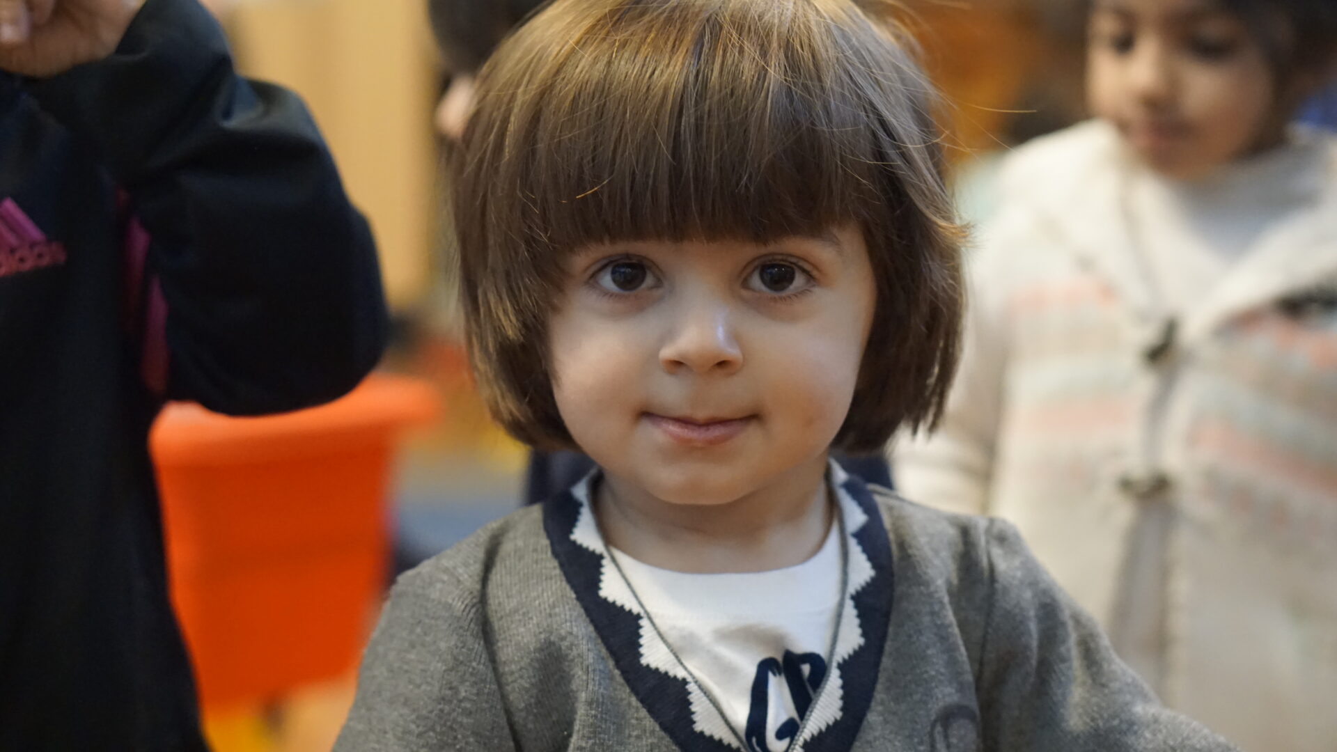 Child with brown hair smiling at camera