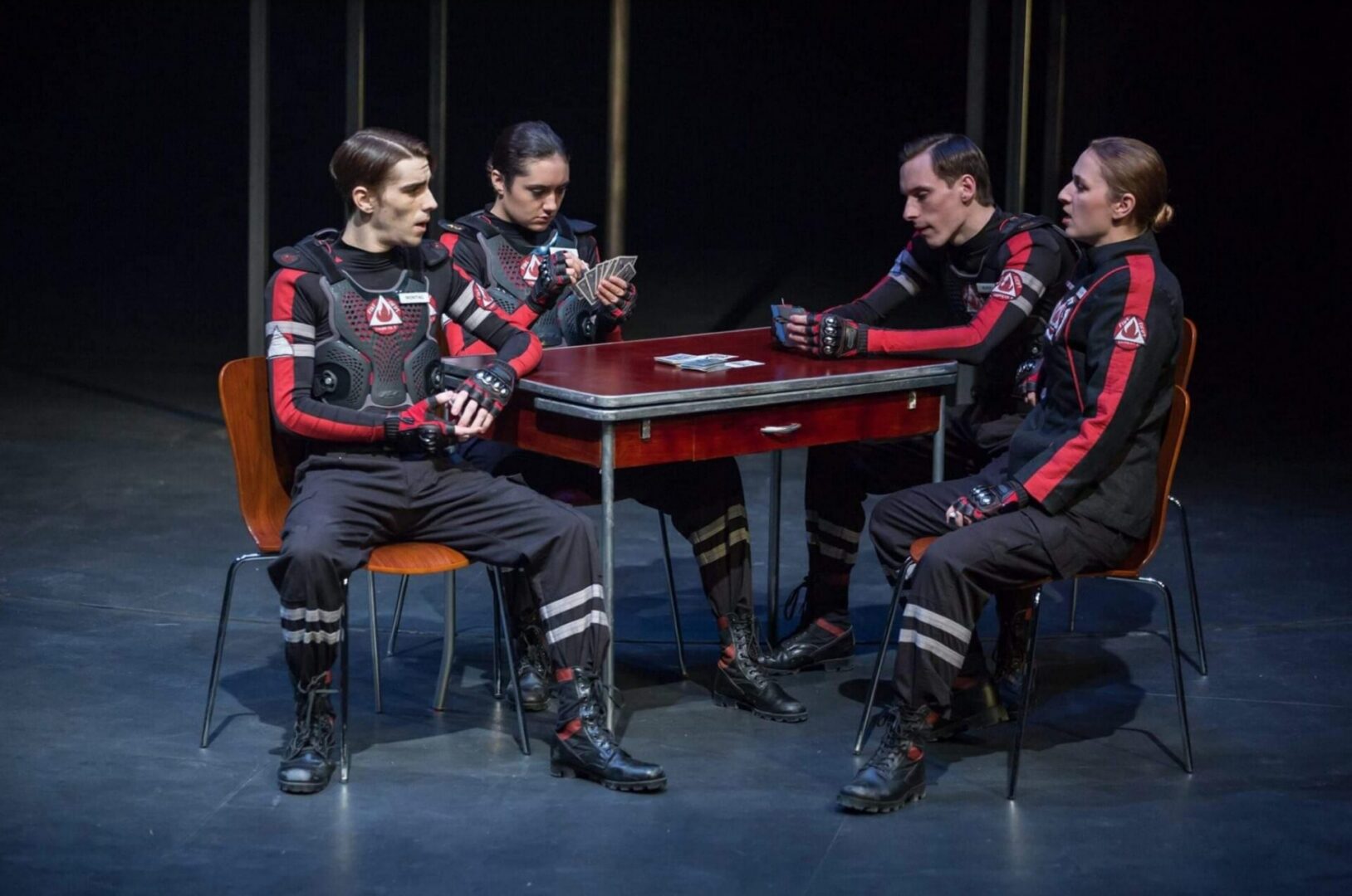 Group playing cards in a theatrical setting.