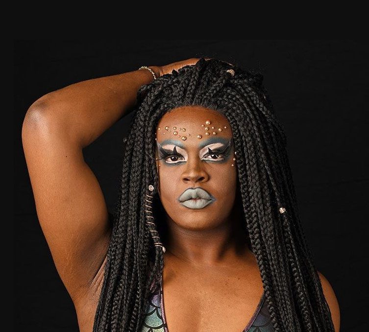 Person with braided hair and bold makeup