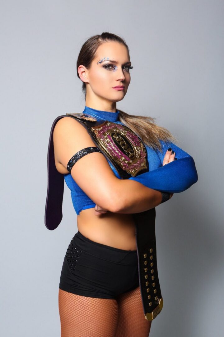 Woman holding wrestling championship belt