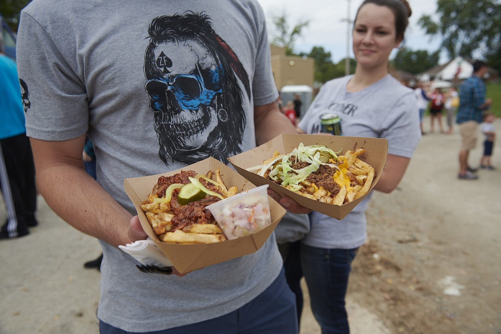 Person with fries and drink outdoors